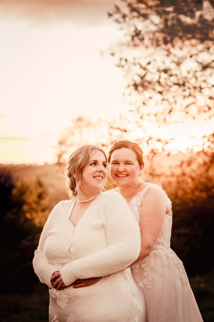 two brides hugging at sunset cotswolds