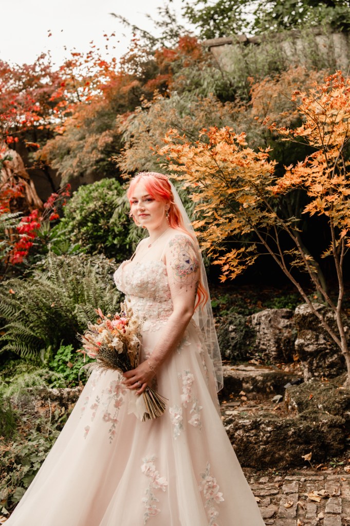 bride with pink hair in autumn garden