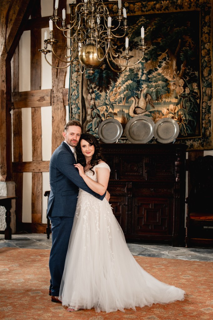wedding couple hugging in grand hall castle wedding