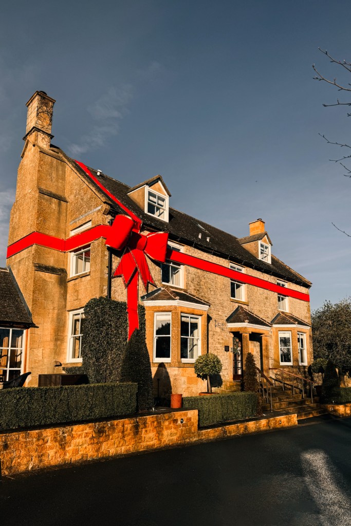 hotel decorated for Christmas with a giant bow Dormy House Cotswolds UK