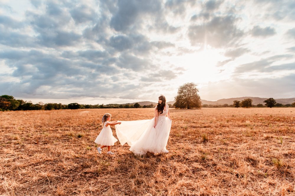 bride and flower girl on a field dreamy wedding photography