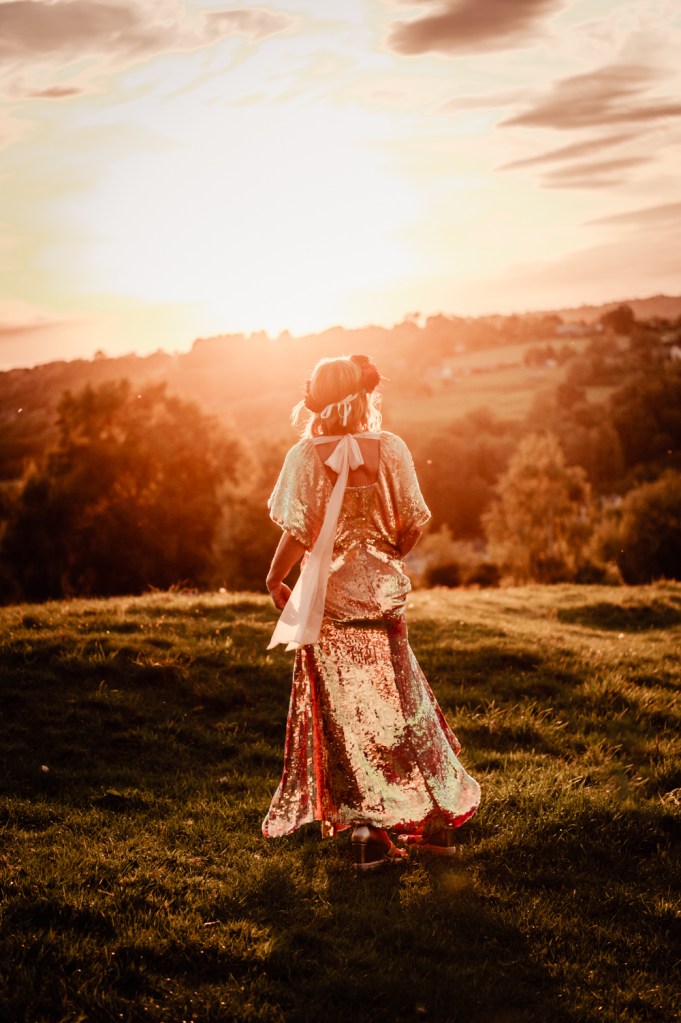 bride in a gold dress and flower crown at sunset 