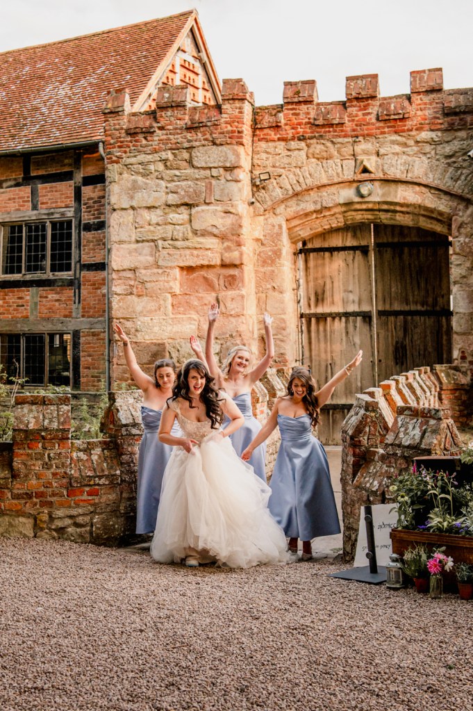 bridal party dancing on a castle bridge fun wedding