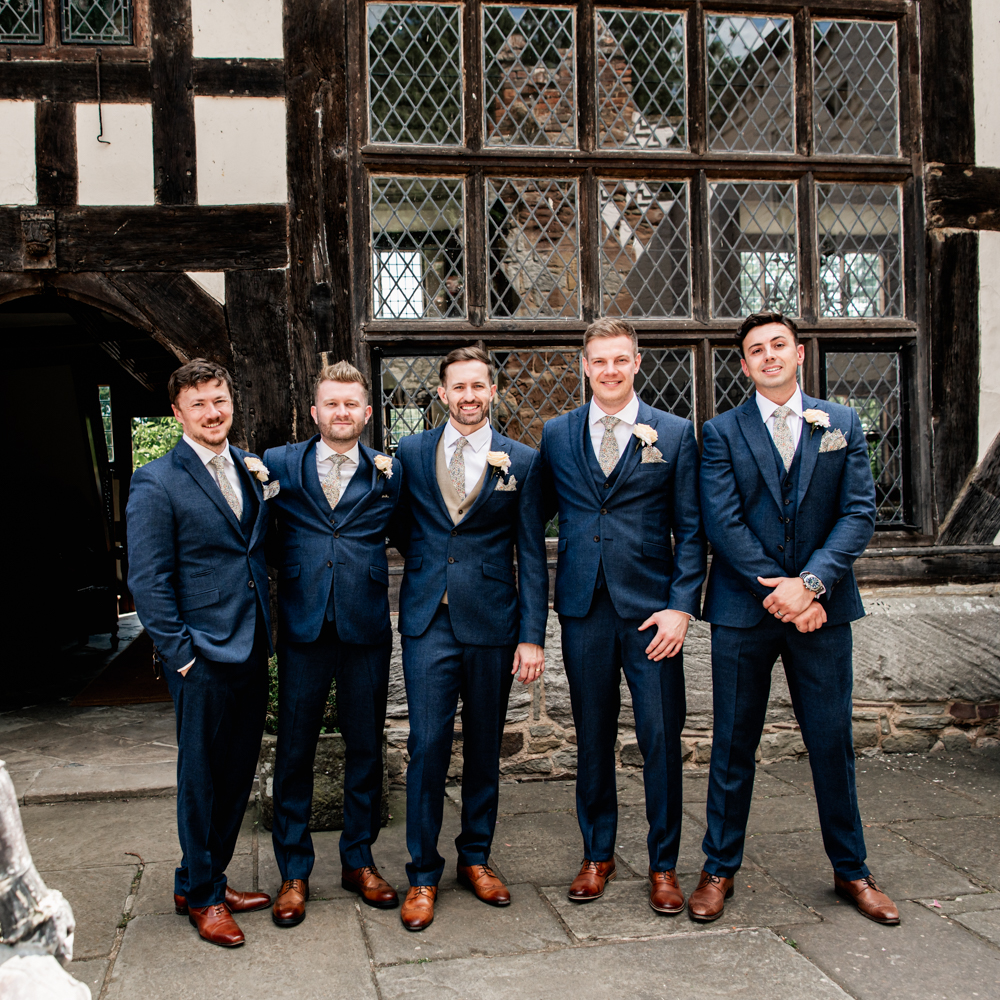 groomsmen in front of tudor house castle wedding