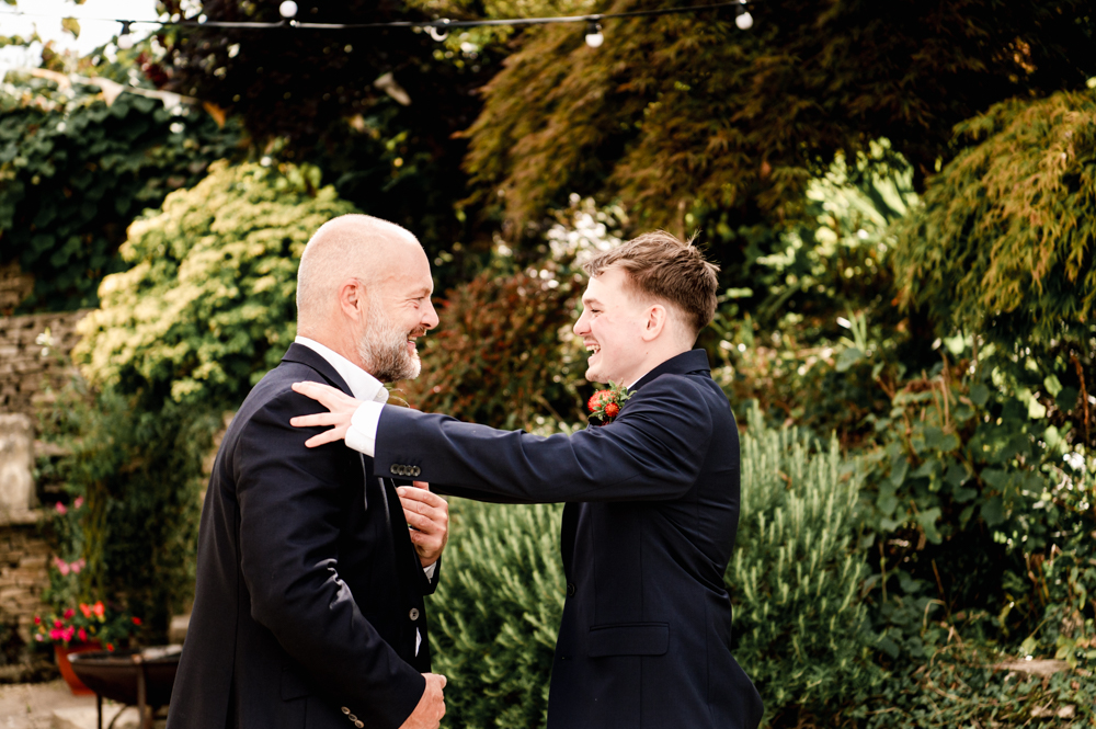 son hugging father wedding