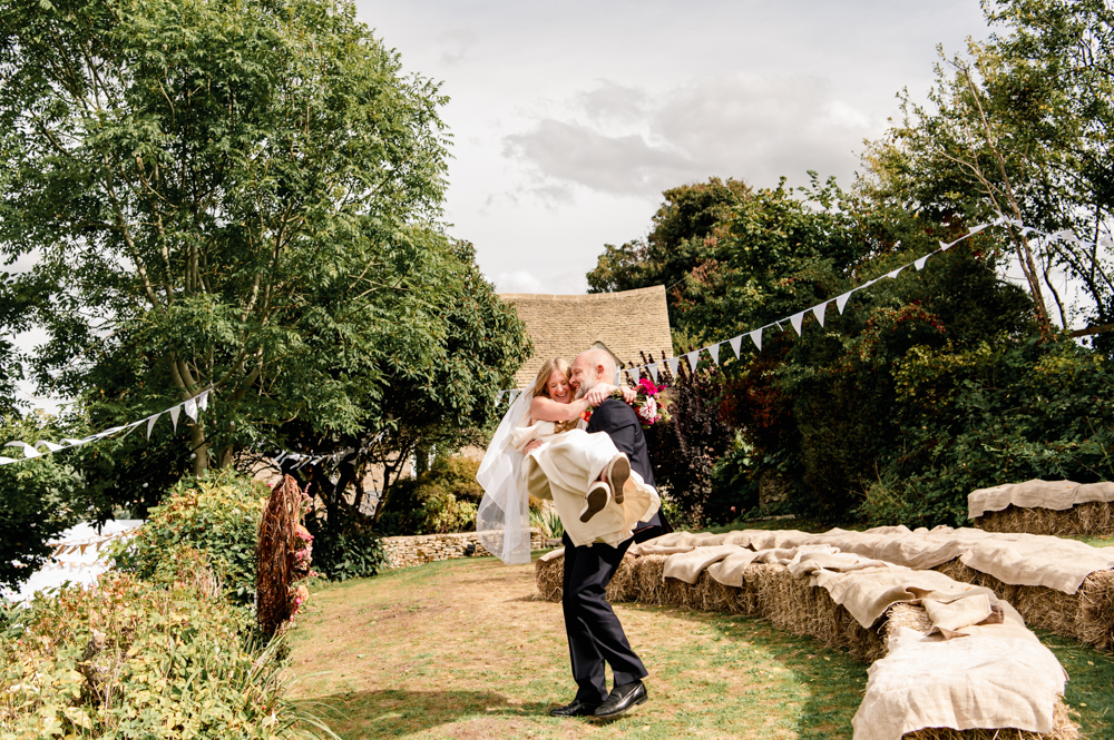 bride and groom by hay bales festival style wedding