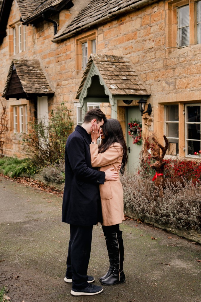 couple kissing in a cotswold village at christmas