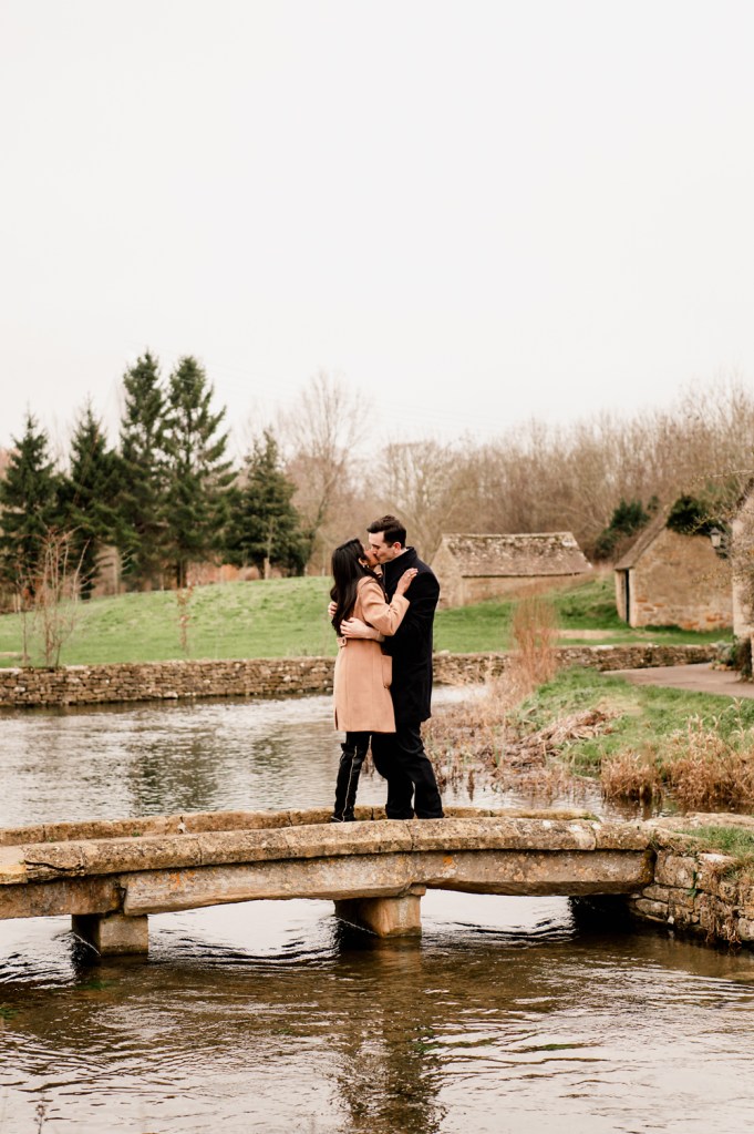 couple kissing on a picturesque bridge in England