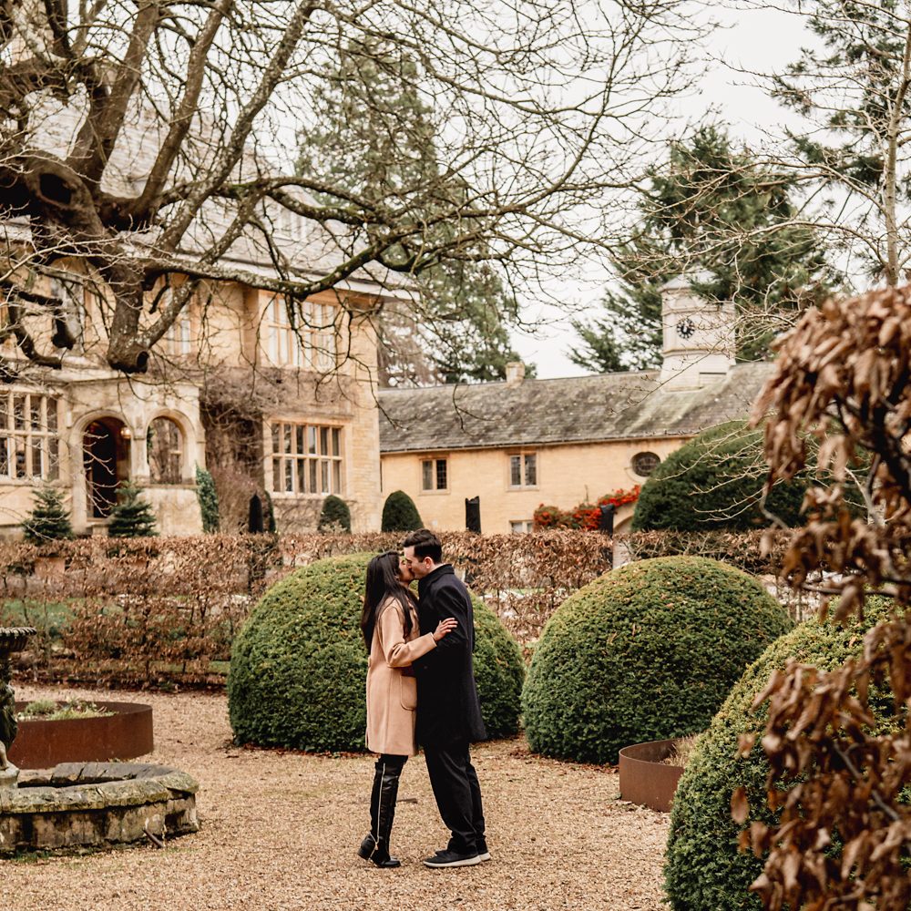 engaged couple kissing in the cotswolds