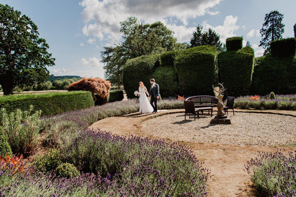 Bride and groom walking in the garden of The Greenway Hotel captured by Cheltenham wedding photographer