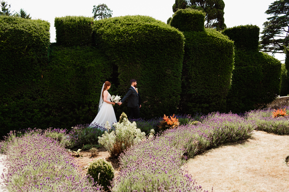 Bride and groom walking in the garden of The Greenway Hotel captured by Cotswolds wedding photographer