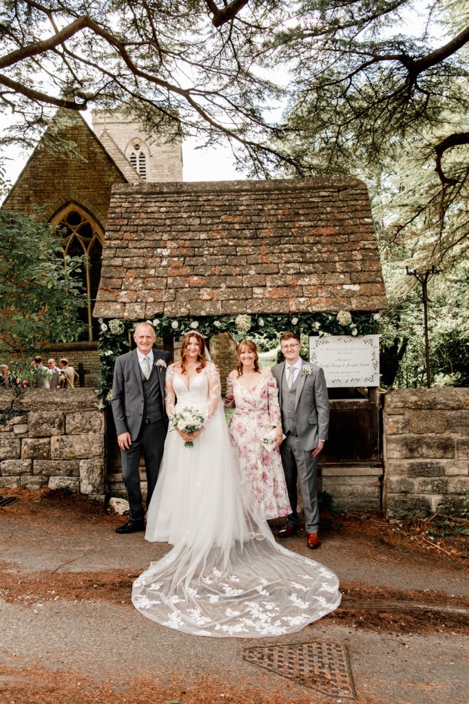 bride and parents by church gate wedding