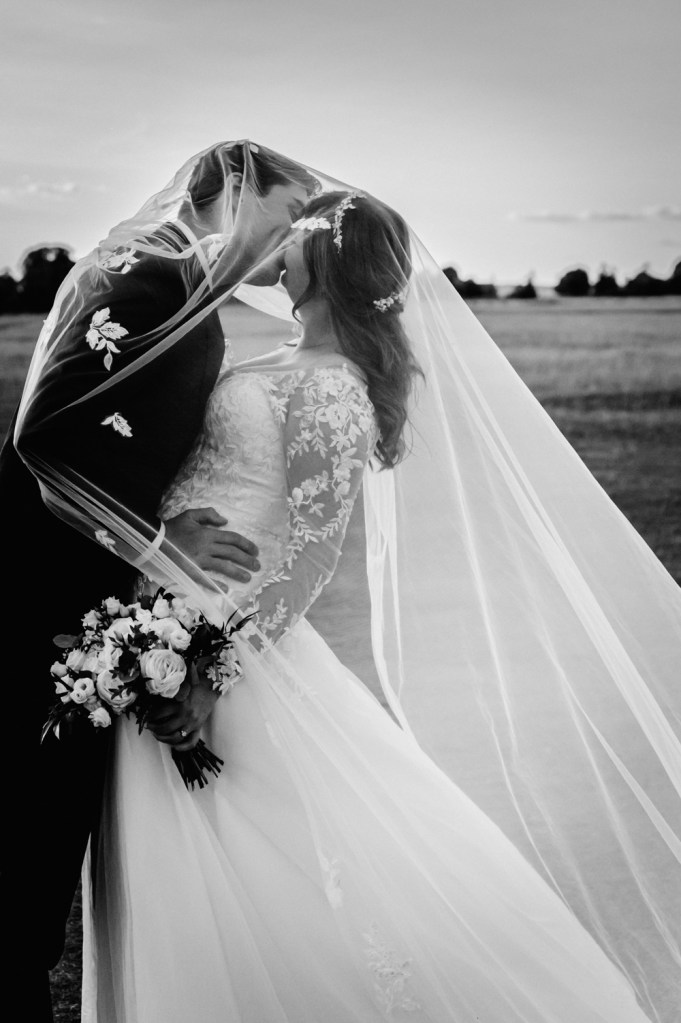 bride and groom under veil