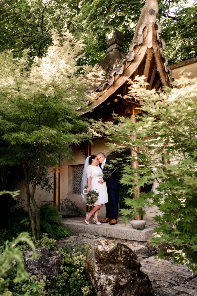 older bride and groom under oriental arch matara centre