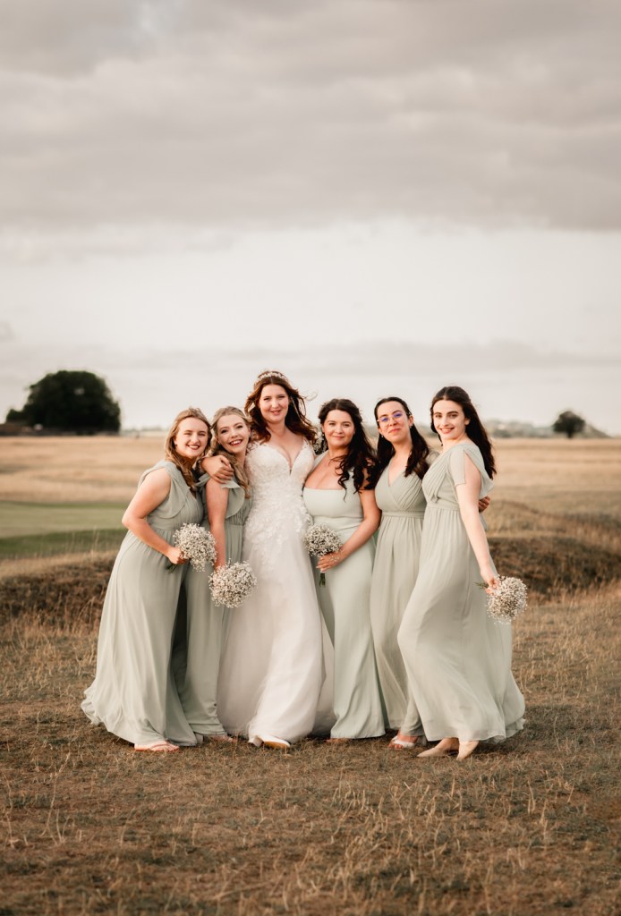 bride and bridesmaids in a field
