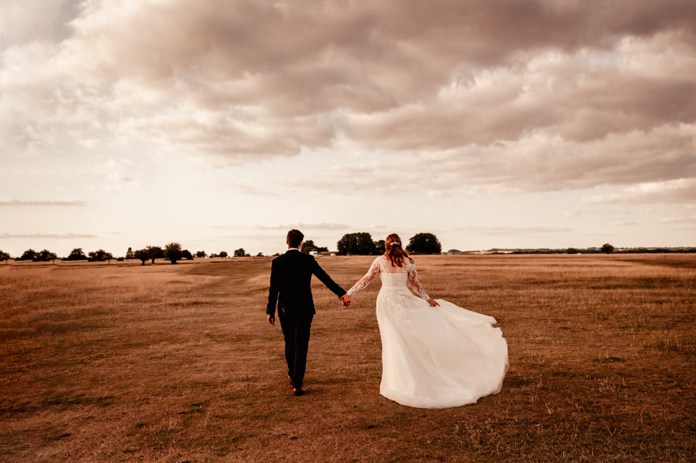 bride and groom walking on the common old lodge wedding minchinhampton 