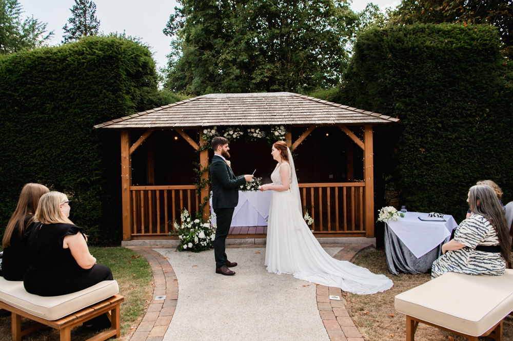Bride and groom getting married outside  in the garden garden of The Greenway Hotel near Cheltenham
