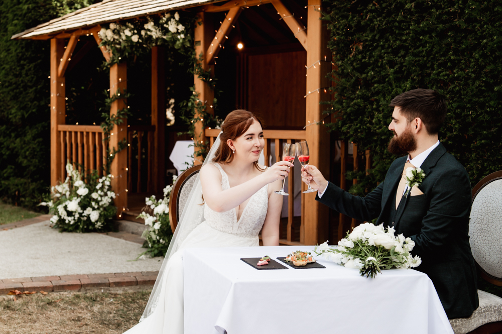 Bride and groom toasting in a country garden  captured by Cotswold wedding photographer