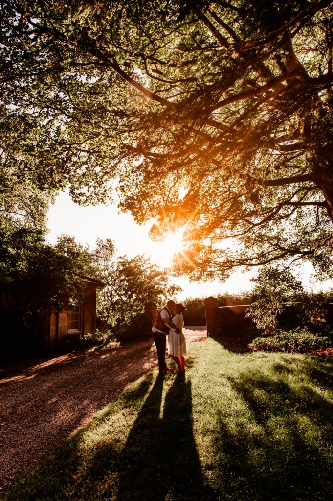 older bride and groom kissing at sunset 